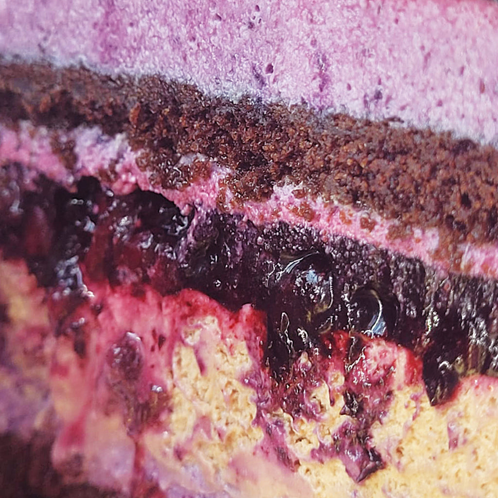 Secțiune din tortul Amurg, cu blat de ciocolată, mousse violet de afine și mure, compot de fructe și mousse de ciocolată cu lapte