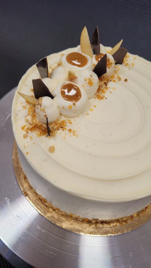 Detaliu de sus al tortului Armonie de Toamnă, cu ganache de vanilie, măr, ciocolată și nucă caramelizată